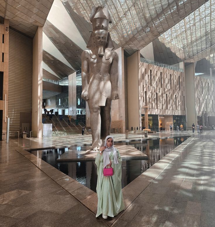 Visitor admiring the colossal Ramesses II statue inside the Grand Egyptian Museum