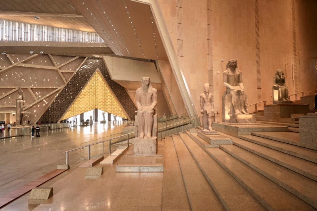 The modern facade and prime location offer stunning views of the pyramids, blending ancient wonders with contemporary design.
Museum Overview & Architecture
Designed by Heneghan Peng Architects, the GEM spans nearly 500,000 square meters on the Giza Plateau. Its striking translucent stone facade and geometric patterns evoke ancient pyramids while allowing natural light into vast galleries.
Key features include:

Grand Egyptian Musuem